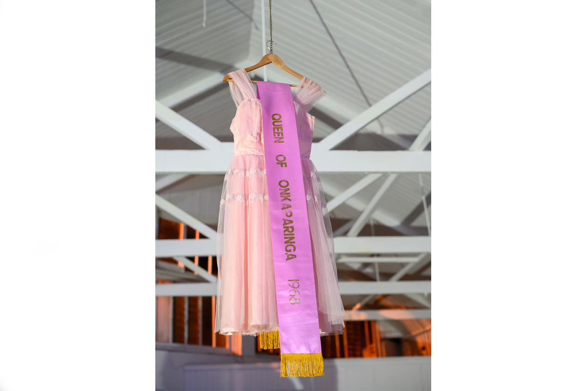 Dress hanging with a pink sash that says "Queen of Onkaparinga"
