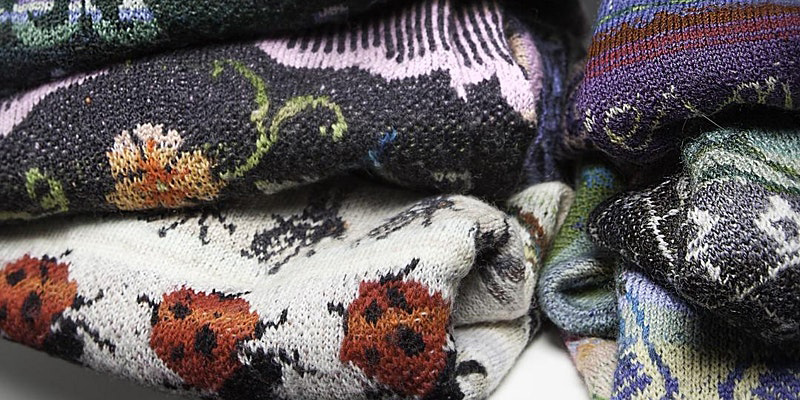 Close up of folded knitted woollen jumpers.